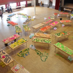 mehrere Tische mit Domino Kunstwerken, miteinander verbunden