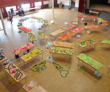 mehrere Tische mit Domino Kunstwerken, miteinander verbunden