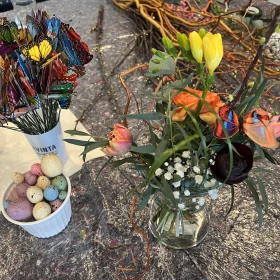 Blumen in einem Glas mit Dekoration daneben