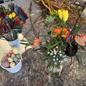 Blumen in einem Glas mit Dekoration daneben