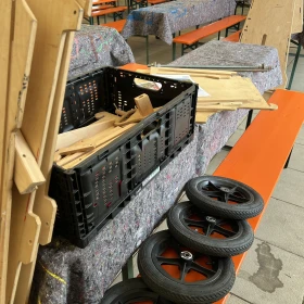 Bausatz für eine Seifenkiste liegt auf dem Tisch, Reifen für Seifenkiste liegen auf einer Bank