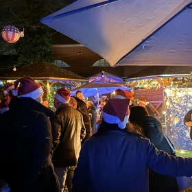 Personen mit Weihnachtsmütze im Außenbereich