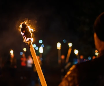 Fackel in der Dunkelheit von einem Mann gehalten