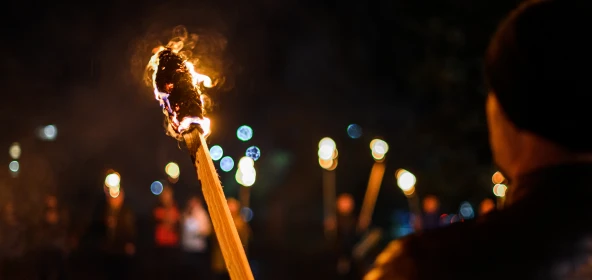 Fackel in der Dunkelheit von einem Mann gehalten