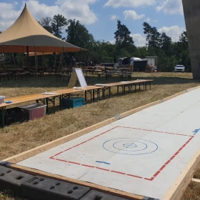 mobile Eisstockbahn im Sommer aufgebaut auf einer Wiese