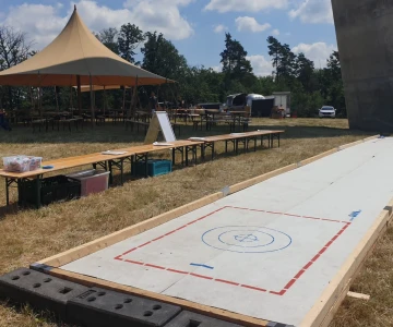 mobile Eisstockbahn im Sommer aufgebaut auf einer Wiese