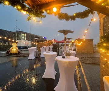 EVINTA_Firmen-Weihnachtsmarkt_Bild02 Weihnachtsmarkt mit Holzhütten und weißen Stehtischen