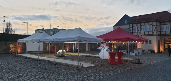 Eisstockbahn im Außenbereich, Schneemann als Deko, rote Pavillons