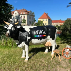 unechte Kuh Elsa mit Strohballen auf einer Wiese