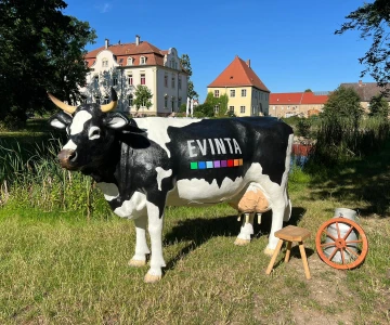 unechte Kuh Elsa mit Strohballen auf einer Wiese