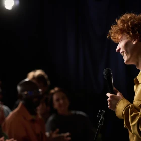 Mann mit Mikrofon spricht zum Publikum