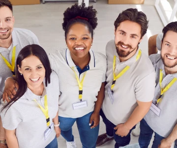 Multikulturelle Gruppe glücklicher Freiwilliger unterschiedlichen Alters, Nahaufnahme. Porträt von Mitarbeitenden einer Wohltätigkeitsorganisation. Konzept: zufriedene Emotionen, Zusammenhalt, freiwilliges Engagement.