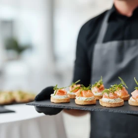 Person trägt ein Tablett mit Vorspeisen