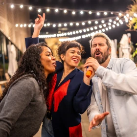 drei Personen singen gemeinsam und freuen sich