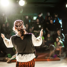 Künstler auf einer Bühne von hinten in Richtung Publikum aufgenommen