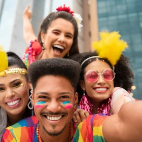 Vier Menschen machen ein Selfie mit bunter Kleidung und brasilianischen Flaggen im Gesicht