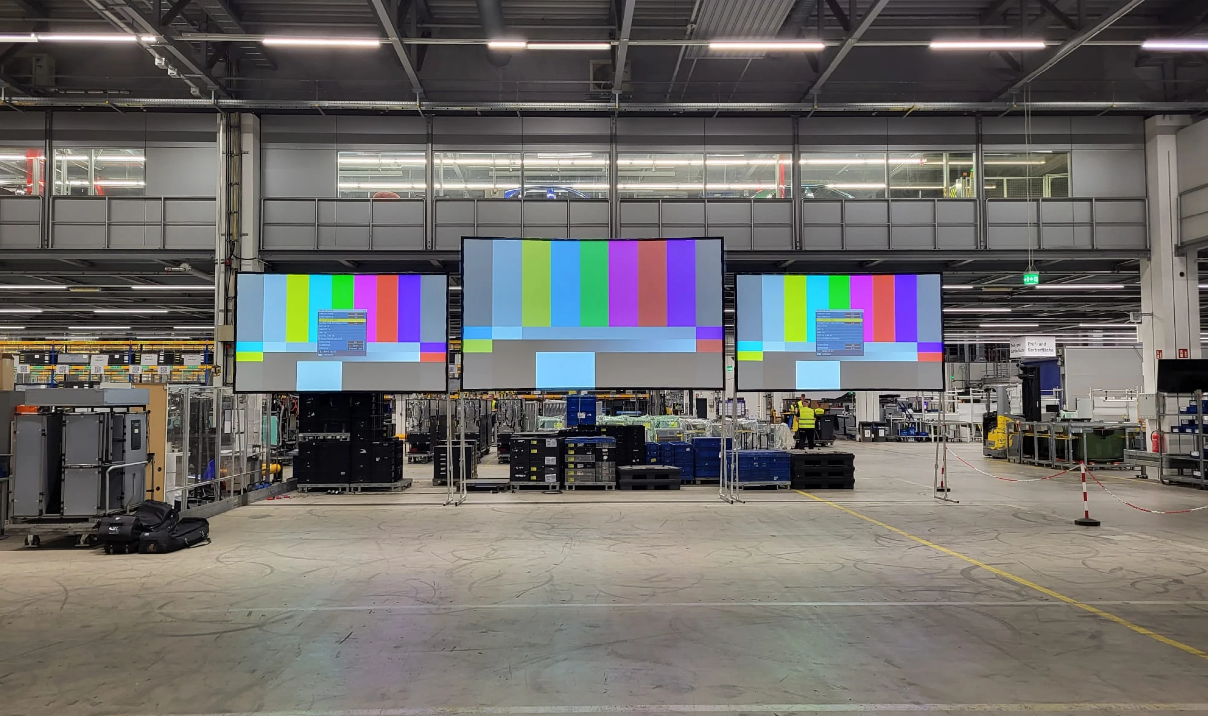 mehrere Leinwände in verschiedenen Größen nebeneinander in einer Halle